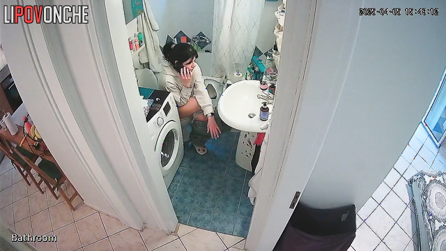 A pretty housewife washes her butt while talking on the phone