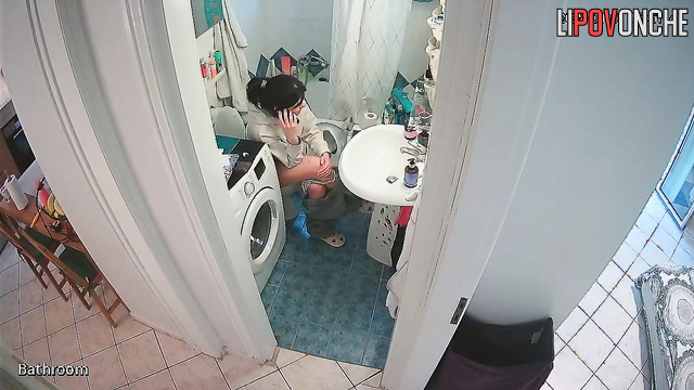 A pretty housewife washes her butt while talking on the phone