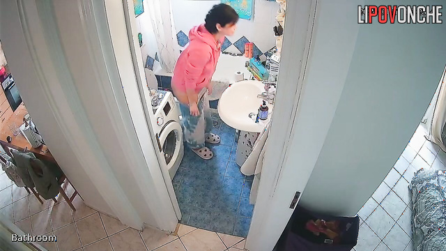 A brunette washes her bare, sexy butt while sitting on the toilet