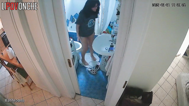 A gorgeous girl in glasses seductively takes off her panties in the bathroom