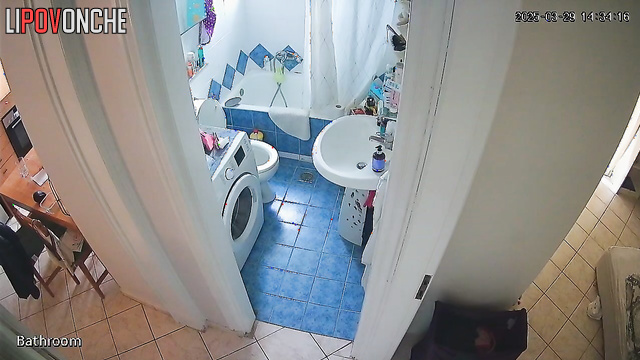 A cute housewife is chatting on the phone while peeing in the toilet
