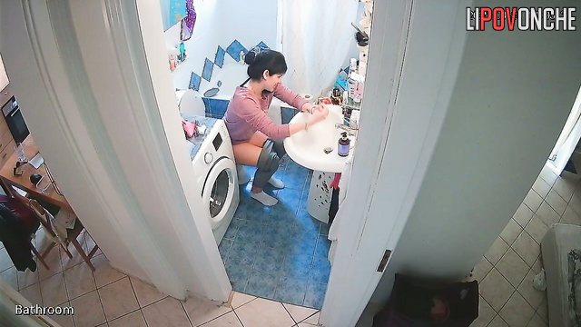 A cute housewife is chatting on the phone while peeing in the toilet