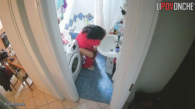 A tired brunette almost fell asleep while sitting and peeing on the toilet