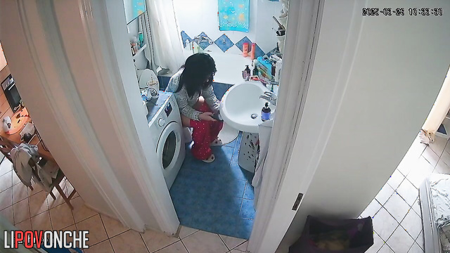 A young teacher wearing glasses pulls down her pants with one hand, exposing her ass