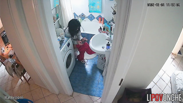 A young teacher wearing glasses pulls down her pants with one hand, exposing her ass