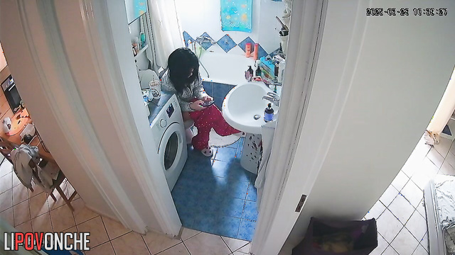 A young teacher wearing glasses pulls down her pants with one hand, exposing her ass