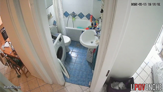 A cute brunette is drinking a Coke while sitting on the toilet