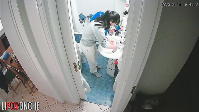 After washing her hands, a delightful cutie pulls down her panties to pee