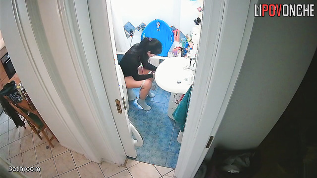 A cute brunette with a sexy ass stands in the restroom with her panties down