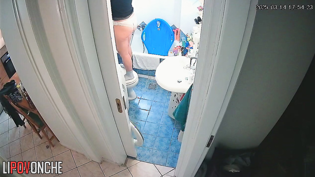 A cute brunette with a sexy ass stands in the restroom with her panties down