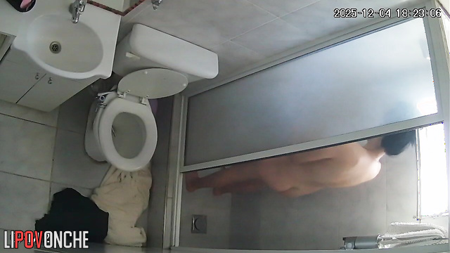 A hidden camera captured the sexy butt of a brunette washing herself in the shower