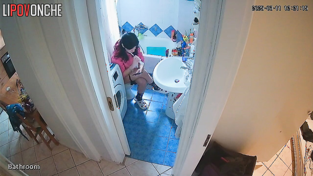 A cute housewife brushes her teeth while sitting on the toilet with her bare ass