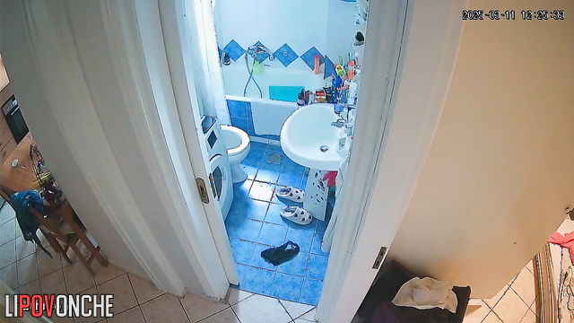 A cute housewife brushes her teeth while sitting on the toilet with her bare ass