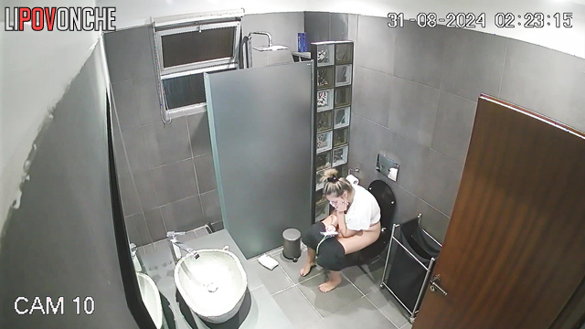 The cheerful blonde prefers to pee in the restroom with her phone in her hands