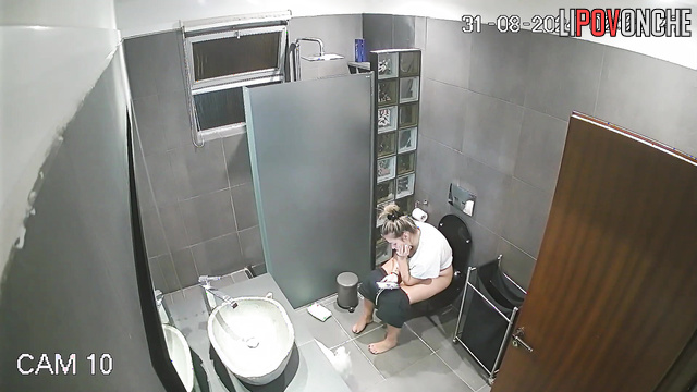 The cheerful blonde prefers to pee in the restroom with her phone in her hands