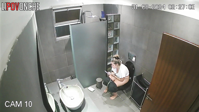 The cheerful blonde prefers to pee in the restroom with her phone in her hands