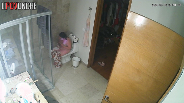 A sexy mommy seductively slips her jumpsuit off her chic body to sit on the toilet