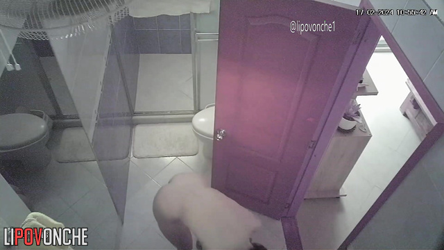 Big-breasted brunette oils herself up in the shower room