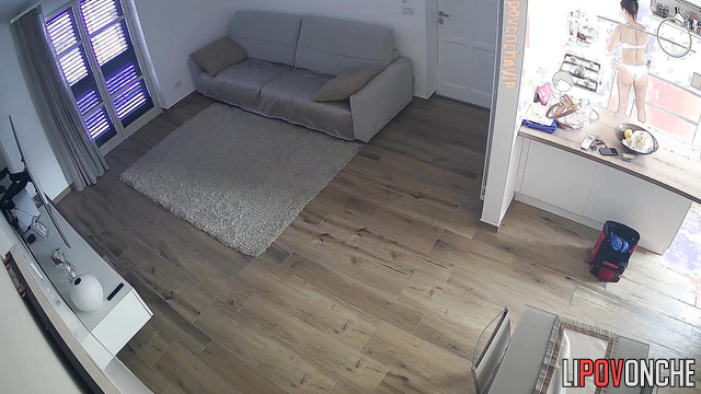 A slim brunette in seductive white lingerie is cleaning her apartment
