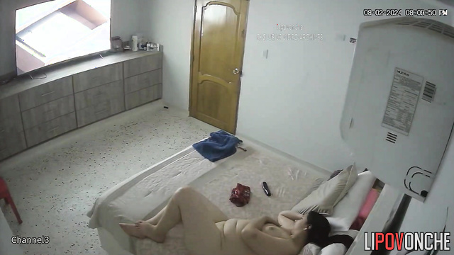 A sexy, chubby brunette, completely naked, is bored in bed while watching TV