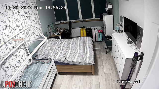 A completely naked woman with large breasts is making the bed in the bedroom