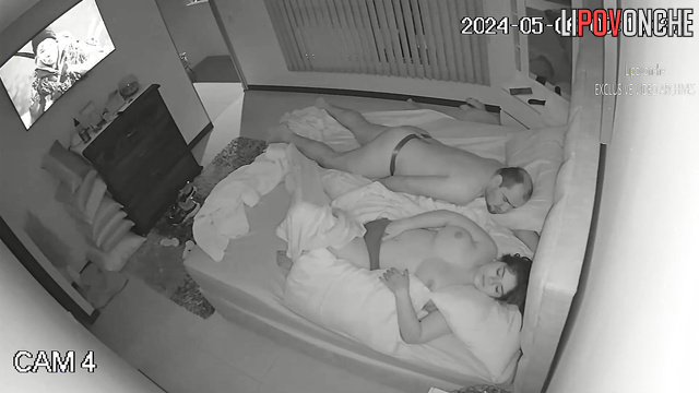 A busty girl plays with her hot pussy while her balding husband sleeps