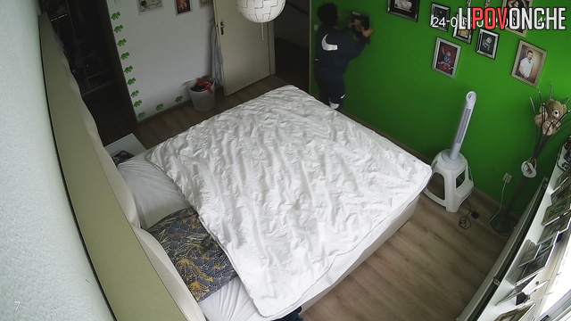 A cute, curly-haired brunette tidies up the bedroom after a wild romp with her lover