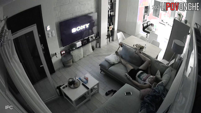 A bored mommy masturbates while watching porn on a big-screen TV