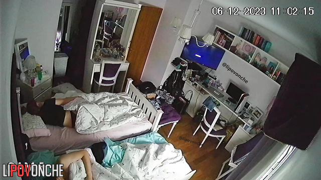 Brother and sister kiss under the blanket while parents are sleeping